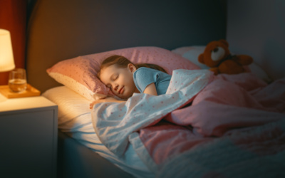 Adorable little child is sleeping in the bed.
